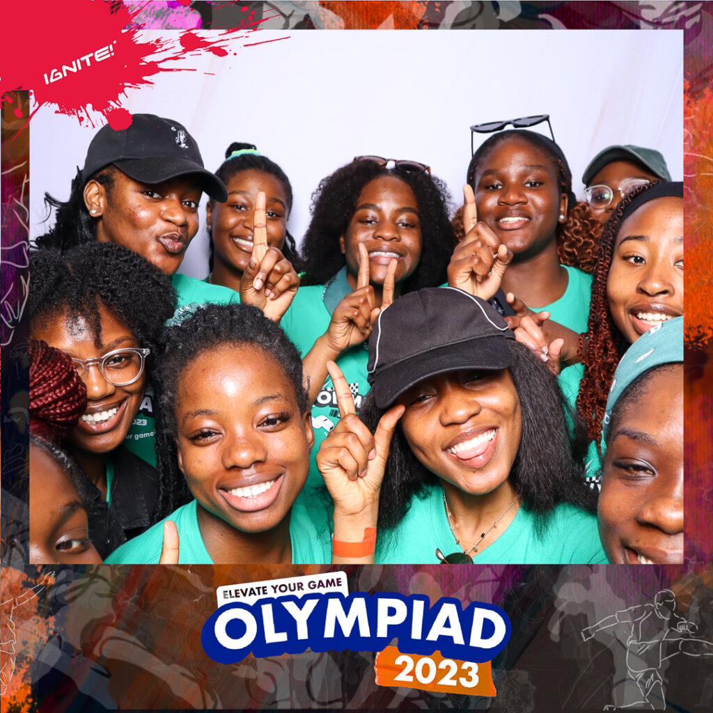 A group of young people posing for a photobooth photo with holding up their fingers at the Olympiad event at House of Praise
